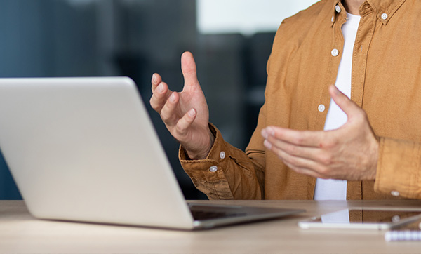 orange hand holding a house symbol representing home ownership benefits for 8 families